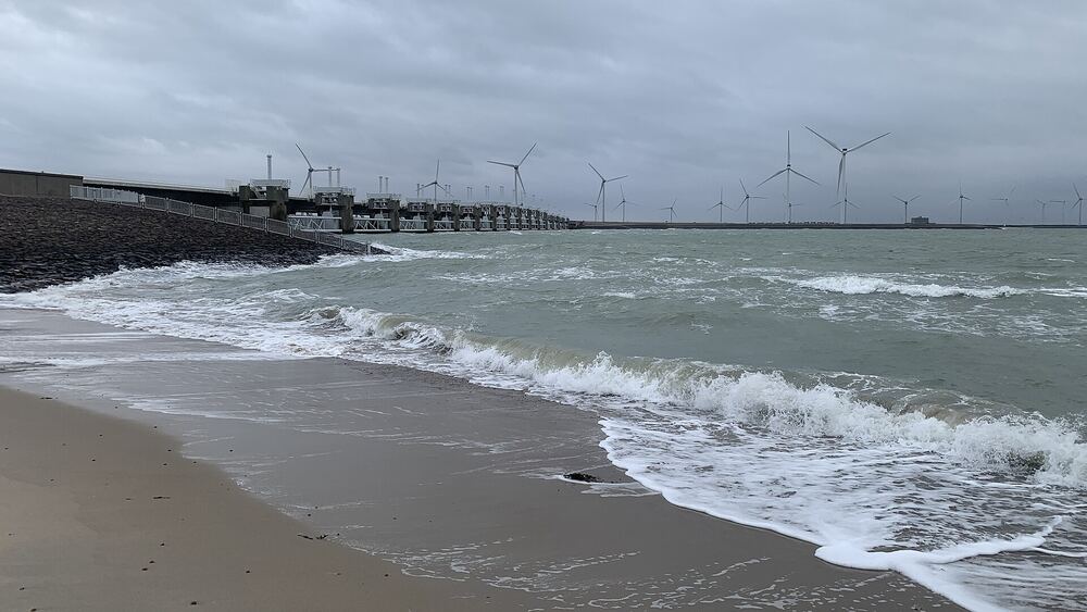 De Oosterscheldekering bij stevige wind met golven op het strand